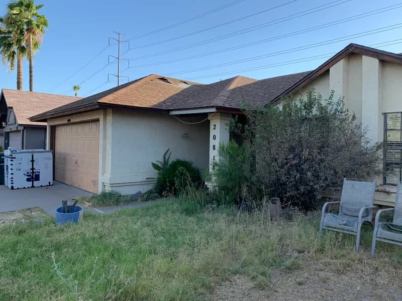 Dated single-story Phoenix home with an aging roof and overgrown front yard on N 34th Dr, purchased for cash by Highest Cash Offer